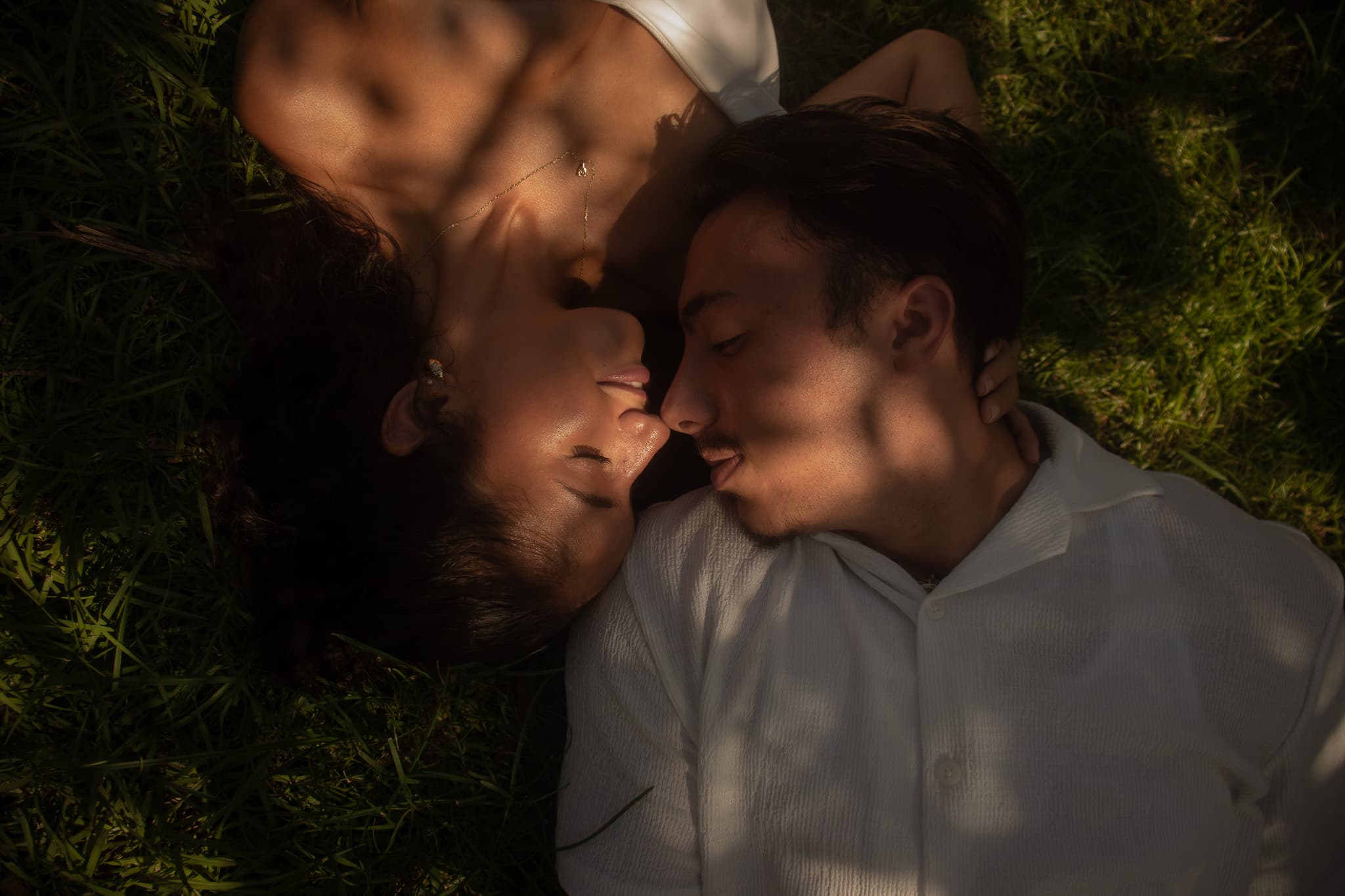 A couple lying together in golden, dappled light