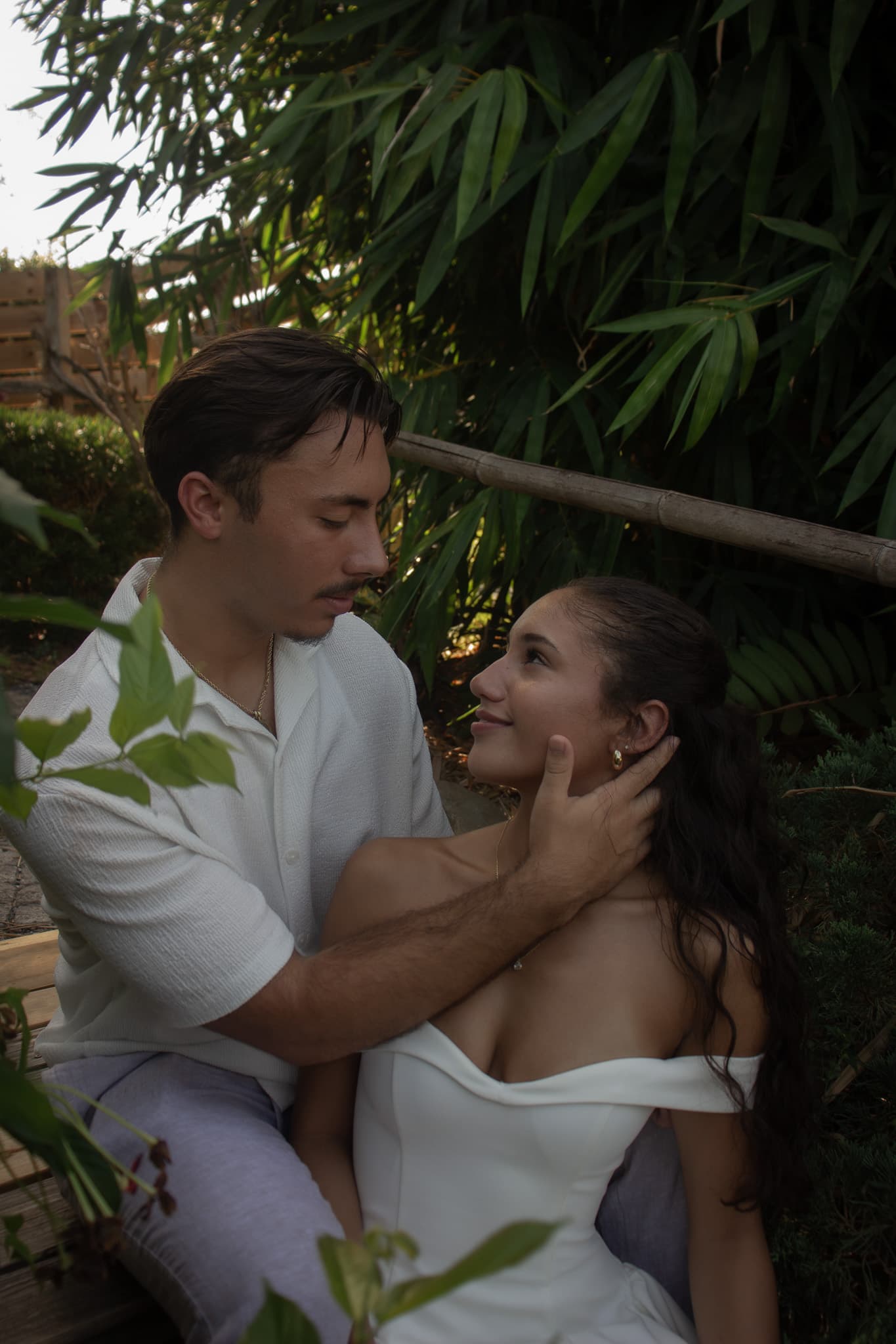 A couple framed by green bamboo and warm light