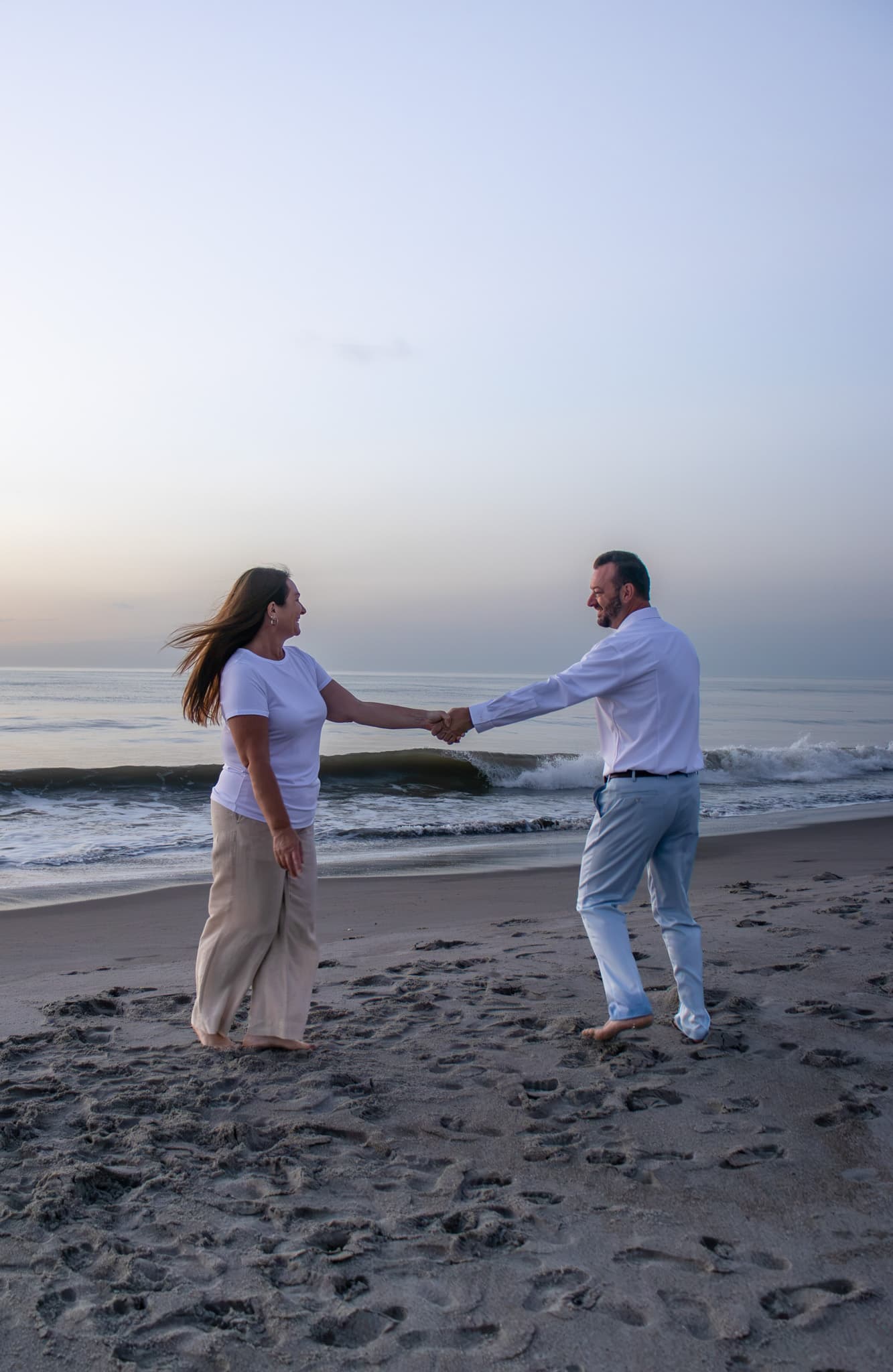 Couple holding hands beside the ocean near Melbourne, Florida