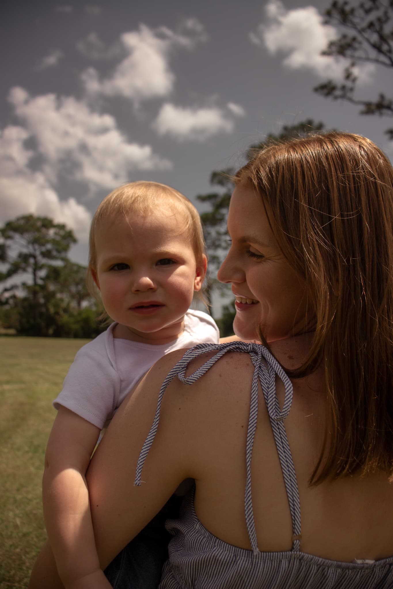 Close portrait of a mother holding her toddler outdoors