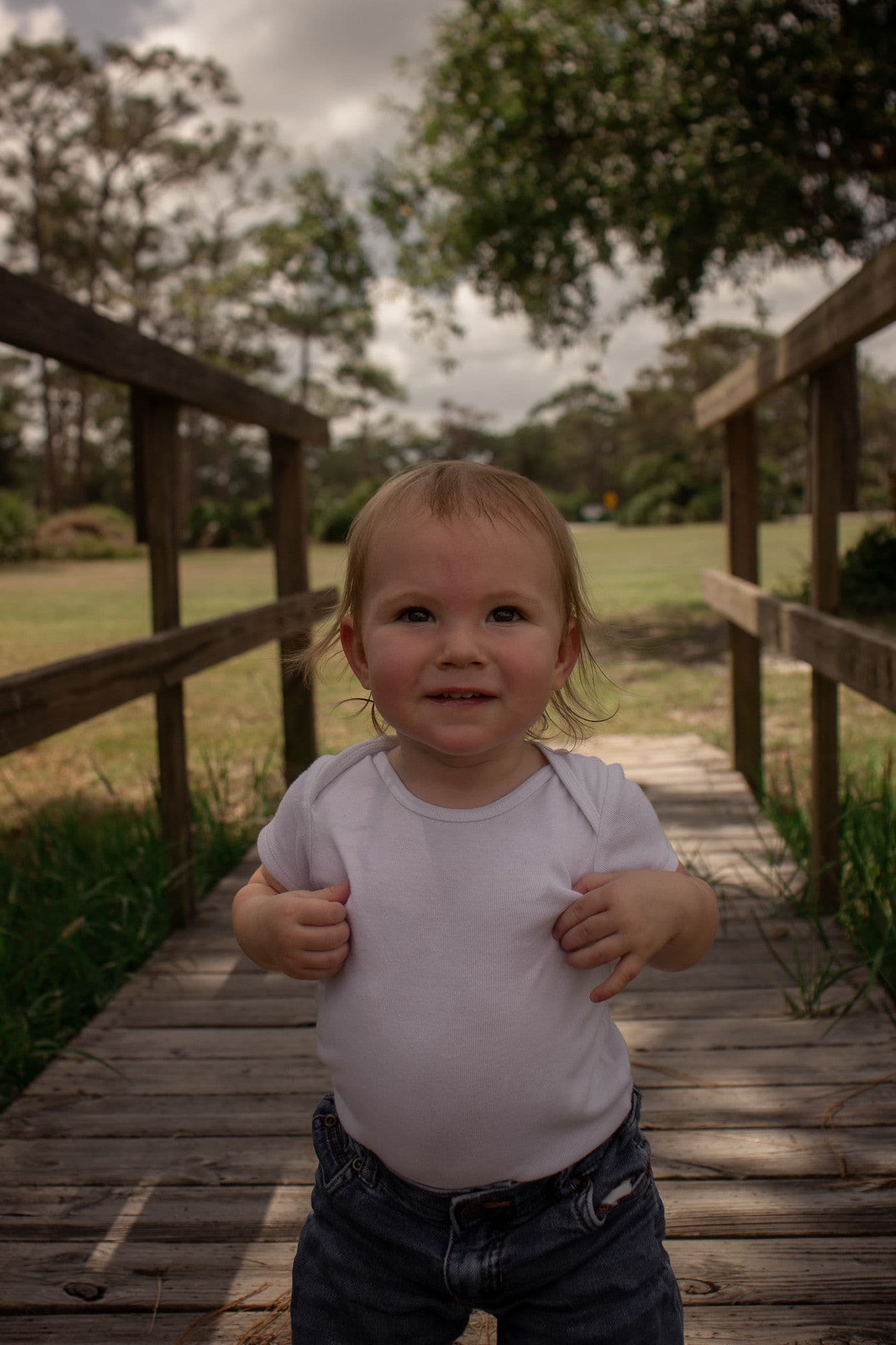 A child standing on a wooden boardwalk