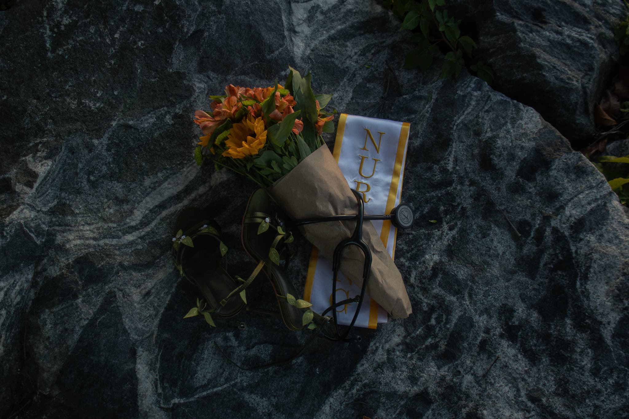 Graduation flowers, nursing sash, shoes, and stethoscope detail photograph
