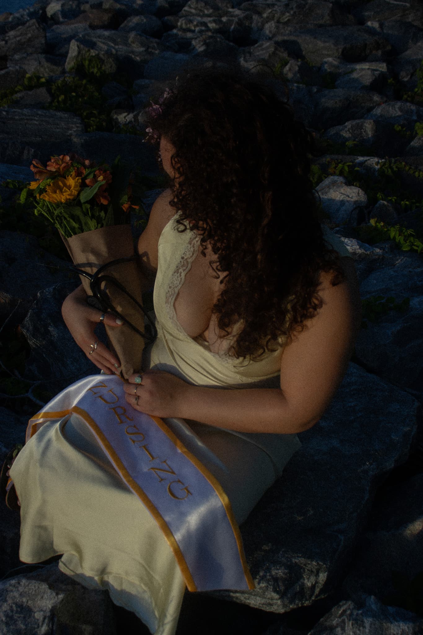 Graduate seated with flowers during a golden-hour portrait session
